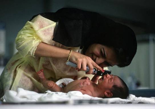 Photo: Veiled female doctor examines baby